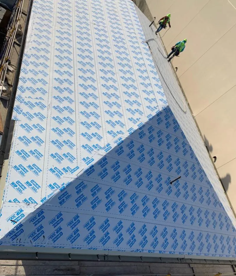 Professional roofers installing underlayment on a metal roof in Newton